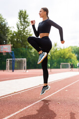 Fitness woman doing cardio interval training outdoors. Female in sportswear exercising outdoors in...