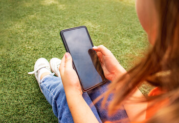 phone in the hands of a child close-up on a background of green grass, Wireless technology, online learning and shopping, communication in social networks, child blogger,