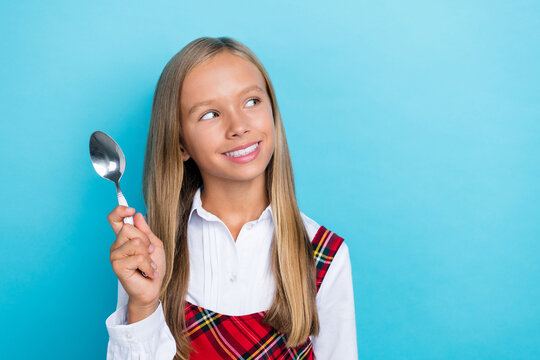 Closeup Photo Of Young Little Cute Nice Schoolgirl Positive Toothy Beaming Hold Spoon Want Eat Food Empty Space Isolated On Blue Color Background