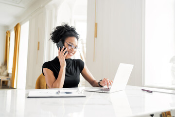 Uses a computer in the new office. A female freelancer career in the company, makes an online report in the office on the project.
