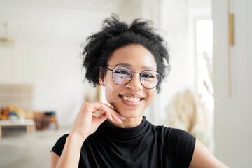 Portrait of a woman with glasses in the office smiling and looking at the camera