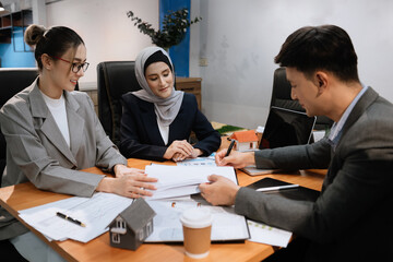 Real estate broker agent presenting and consult to customer to decision making sign insurance form agreement, home model, concerning mortgage loan offer in office.