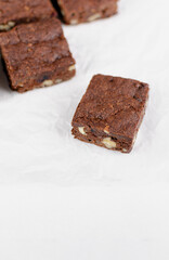 Chocolate homemade brownies with dried cranberries and walnuts on the white  background
