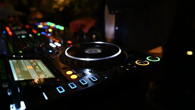 Nahaufnahme einer scratchenden Hand eines DJs an Turntables in Dunkelheit auf einer Veranstaltung