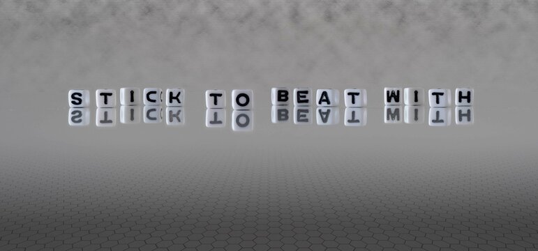 stick to beat with word or concept represented by black and white letter cubes on a grey horizon background stretching to infinity