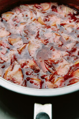 Plum and apple jam. Cooking cooking jam in a frying pan. Homemade jam with sugar syrup. The process of cooking, boiling berries for canning.Close-up top view