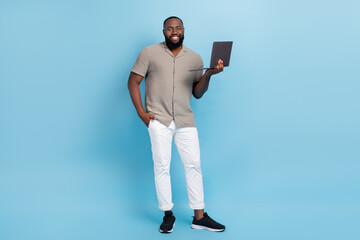 Full body photo of positive cheerful person hold wireless netbook toothy smile isolated on blue color background