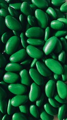 Close up of green drage. Green background with green dragees. Green chocolate coated dragee with almond flavour.