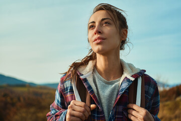 close up outdoors portrait beautiful confident woman in nature looking away during hiking by mountains range - 528942187