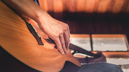 Close-up of the hands and fingers of a male musician playing an acoustic guitar.Musical guitar instrument for recreation or Relax hobby passion concept.