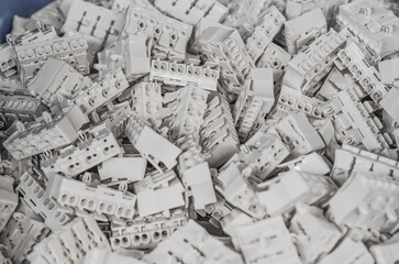 Pile of white electrical connection blocks for cables. Abstract industrial background.