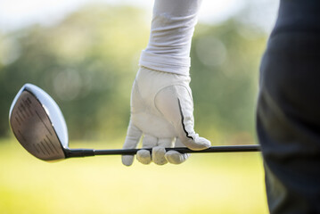 Close up professional  golf player with club on course