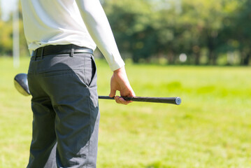 Close up professional  golf player with club on course