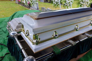 As part of the funeral service in a cemetery, coffin is placed on an automatic elevator and is...