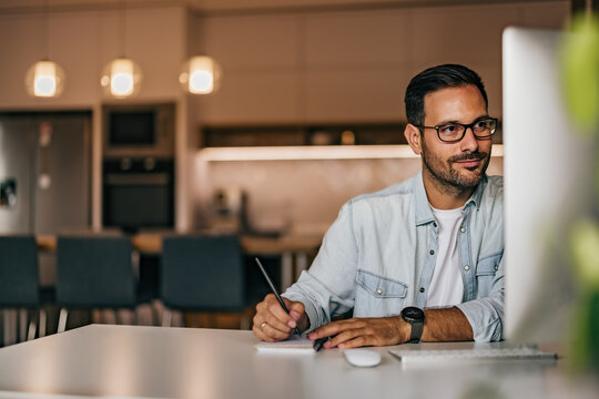 Focused Man Reading Something Online, Making Notes.