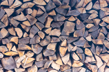 Stacked stack of firewood. Large woodpile with chopped wood. Stacked stack of firewood from the end.