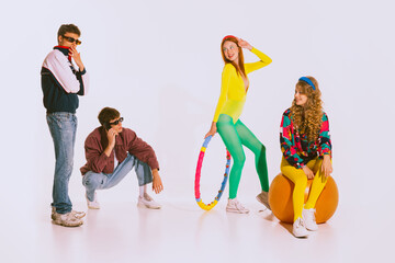 Portrait of stylish young people, boys and girls in bright clothes doing fitness, posing isolated...