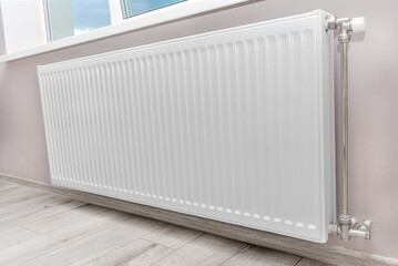Modern radiator under the window. Heat and economy.