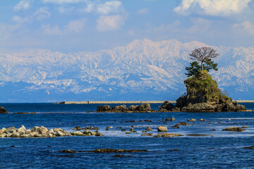 冬の雨晴海岸から日本海越しの雪を被った冬の立山連峰
