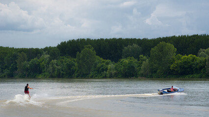 Young man waterskiing on the river on a beautiful summer day