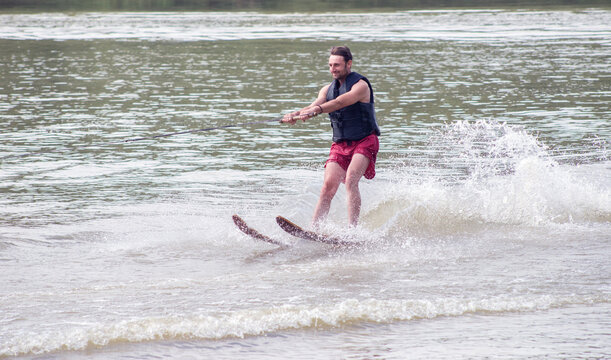 Young man waterskiing on the river on a beautiful summer day