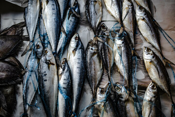 Obraz premium Sun-dried fish on paper for sale in the Ban Na Kluea market, Pattaya, Thailand.