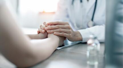 Obraz na płótnie Canvas Doctor holding patient hand. Caring nurse or doctor holding patient hand with care. Closeup view.