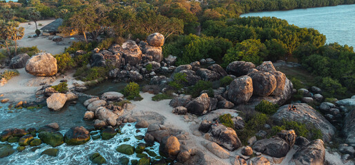 Ocean tropical landscape, rocky coast with fishing boats, drone shot, water and beach.