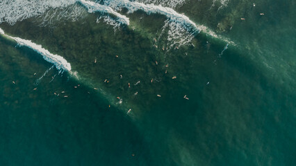 Beautiful view of the sea and the ocean with surfers waiting for the waves.