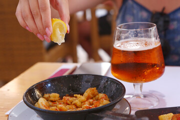 fried shrimps with lemon slice, garlic sauce aioli and tomato ketchup frying pan close up photo...