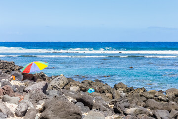 Parasol parmi les rochers d’une petite crique, l’Etang-Salé,  île de la Réunion 