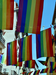 Many rainbow flags of gay community hang outside on the street of Madrid during gay pride days, Chueca district, Spain