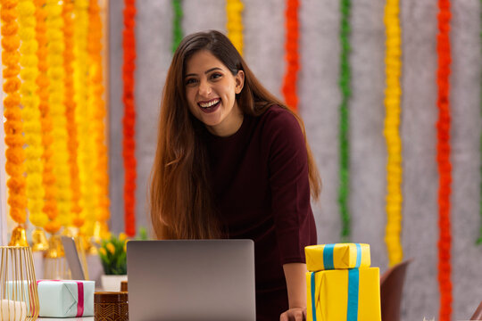 Young woman laughing while working in office during Diwali celebration