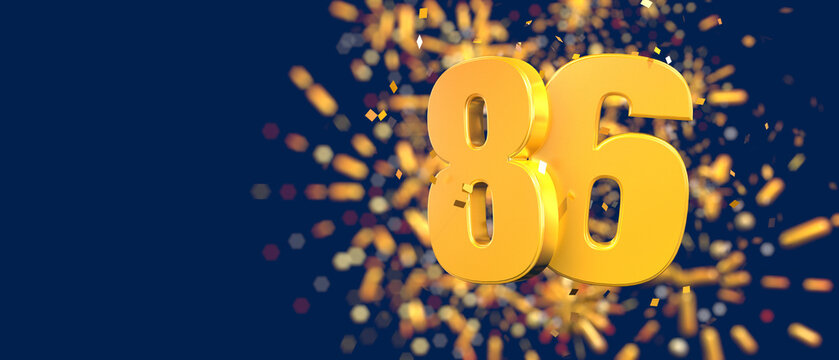 Gold number 86 in the foreground with gold confetti falling and fireworks behind out of focus