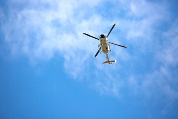 Fototapeta na wymiar Helicopter close-up against the sky. Rescue helicopter flies in the sky with clouds.