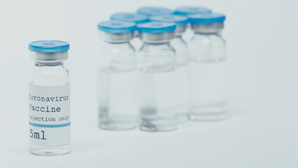 close up of glass bottles with coronavirus vaccine lettering isolated on white.