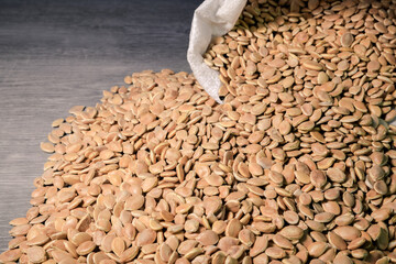 Pumpkin seeds spill out of the bag. Healthy food. Collection, storage and preparation of seeds for...