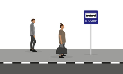 A woman with a sports bag in her hand and a man are standing on the sidewalk near the bus stop sign