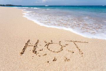 Fototapeta premium The word HOT written in the sand on beach