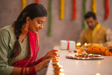 Employees decorating office by placing diyas on table on the occasion of Diwali 