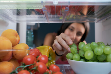 Woman taking fruit in the fridge