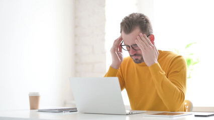 Man having Headache while Working on Laptop