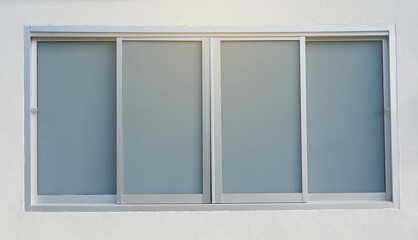 Aluminum sliding window, 4 panels, glass attached with gray glass film sticker. Soft and selective focus.