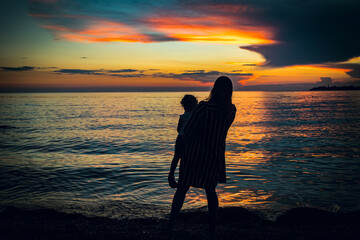 Woman enjoying sunset with her child