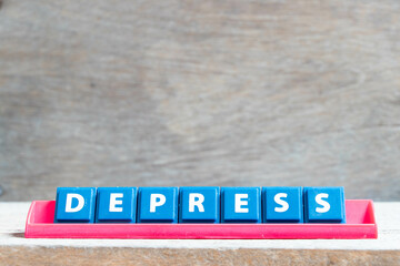 Tile alphabet letter with word depress in red color rack on wood background