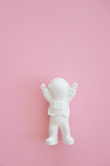 plaster figure of an astronaut on a pink background