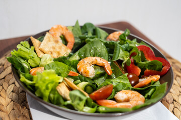 A healthy green garden salad with cooked shrimp