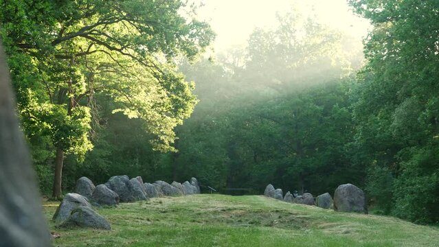 Megalithic tomb (Visbeker Braut) in a forest with sun rays in northern Germany