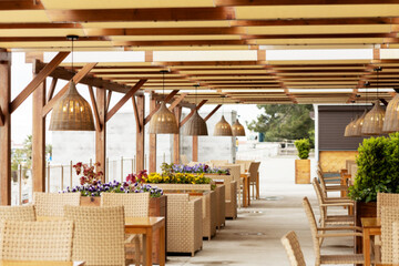 Outdoor cafe with wicker furniture and lamps. Blurred image