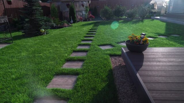 Straight line of new freshly installed green rolled lawn grass carpet along stone pavement sidewalk or backyard on bright sunny day. Grass turf,rolled green grass,material for landscaping territory 